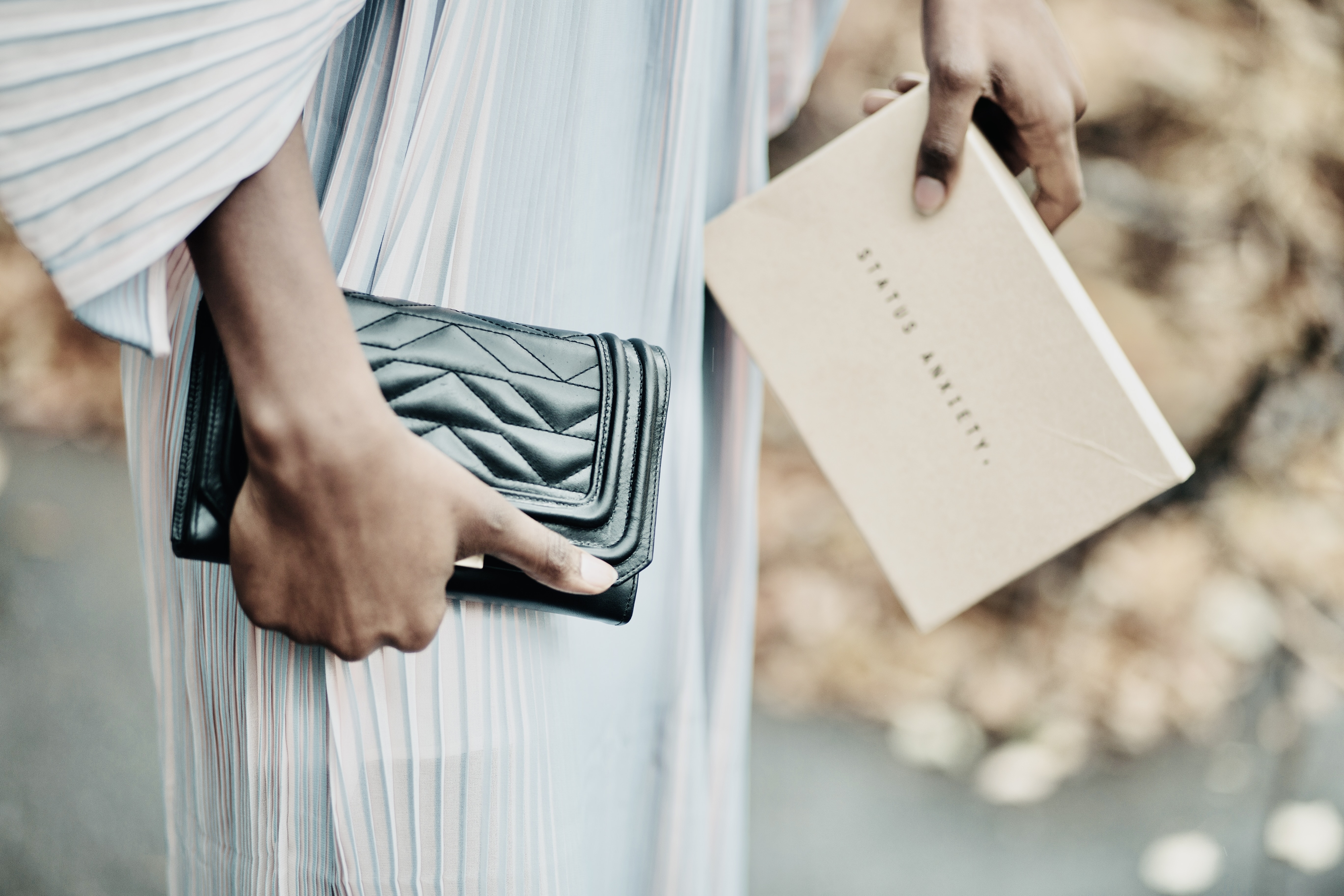 lady holding dark green clutch next to waist